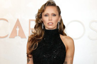 Η Miley Cyrus εμπνέεται από την Pamela Anderson με bombshell updo των ’90s και μαύρο φόρεμα με αβυσσαλέο ντεκολτέ